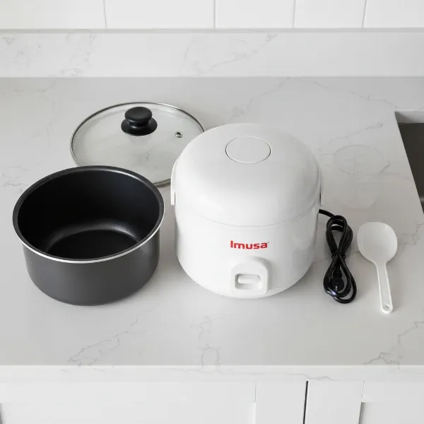 Disassembled Imusa non-stick rice cooker showing inner pot, lid, and main unit on a kitchen counter