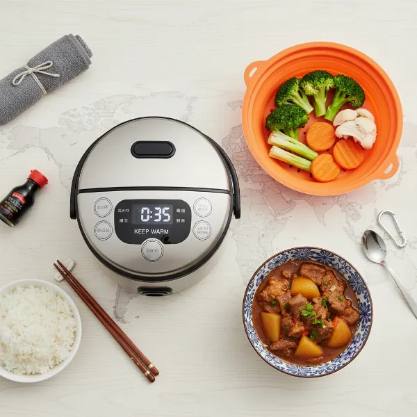 Versatile travel rice cooker displaying various cooking functions, preparing rice, steamed vegetables, and soup simultaneously.