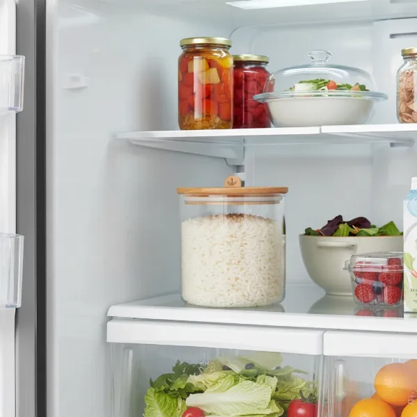 a close-up of cooked white rice being stored in a clear, airtight container in a refrigerator
