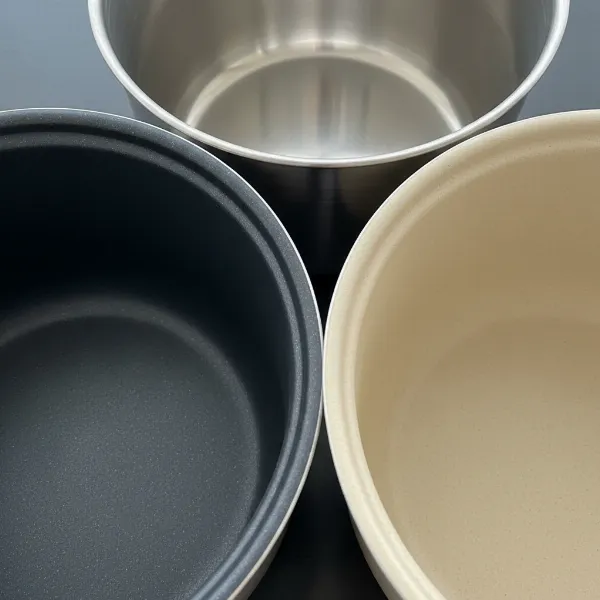 Close-up of different rice cooker inner pots, highlighting various materials like non-stick, stainless steel, and ceramic.